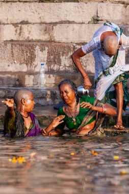 Kel kadınlar Ganj Nehri 'nin kutsal sularında yıkanırlar. Varanasi, Hindistan