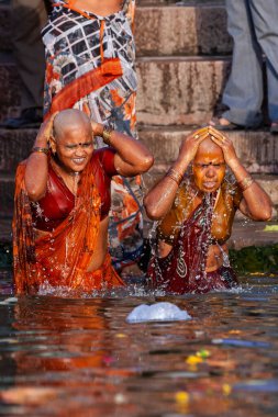 Gülümseyen kel kadınlar Ganj Nehri 'nin kutsal sularında yüzüyorlar. Varanasi, Hindistan