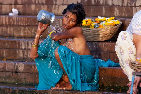 ガンジス川の聖水で銀の瓶から身を入浴青い服の女性 インドのバラナシ — ストック写真