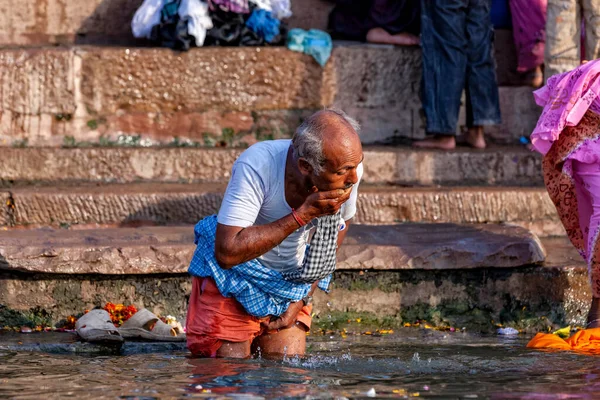 老人が身を洗い ガンジス川の聖水を飲んでいた インドのバラナシ — ストック写真