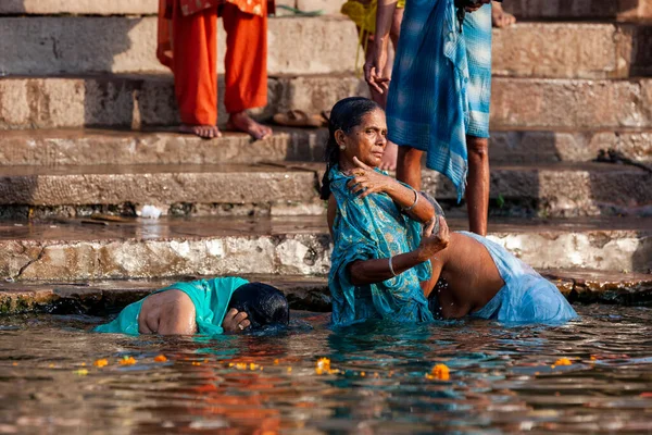 青い服を着た熟女たちがガンジス川の聖水に浸かっている インドのバラナシ — ストック写真