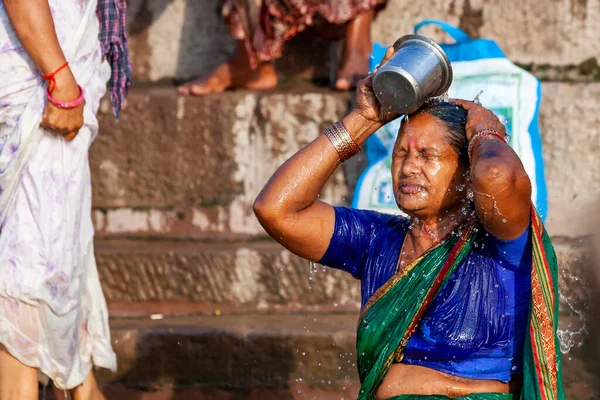グリーンサリの未確認の女がガンジス川の水で銀の瓶から身を洗っていた インドのバラナシ — ストック写真