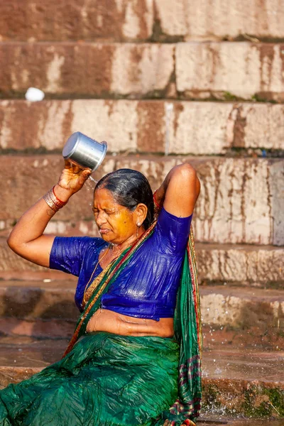 グリーンサリの未確認宗教の女性ガンジス川の聖水で銀のカップから身を洗う インドのバラナシ — ストック写真