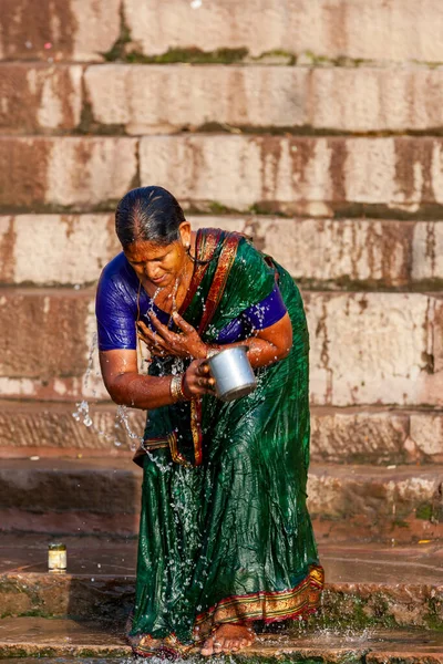 グリーンサリの未確認宗教の女性ガンジス川の聖水で銀のカップから身を洗う インドのバラナシ — ストック写真