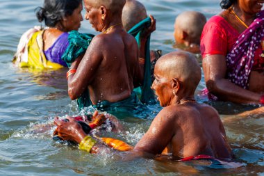 Hindistan, Varanasi - 23 Nisan 2011: Tanımlanamayan insanlar Ganga Nehri 'nde ayin banyosu yapıyorlar. Kutsal ayin banyosu her gün yapılır.