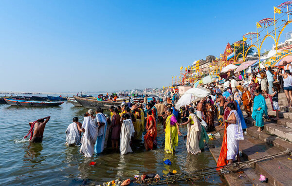 Индия, Варанаси - 23 апреля 2011 года: Неизвестные принимают ритуальные ванны в реке Ганга. Святая ритуальная баня проводится каждый день