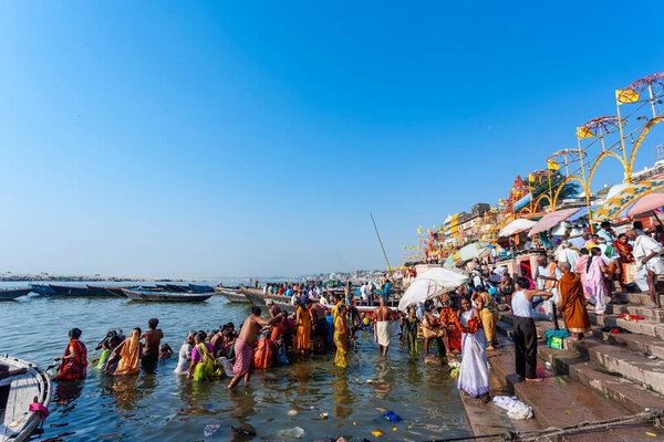 Индия, Варанаси - 23 апреля 2011 года: Неизвестные принимают ритуальные ванны в реке Ганга. Святая ритуальная баня проводится каждый день