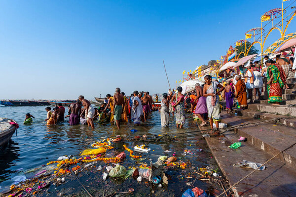 Индия, Варанаси - 23 апреля 2011 года: Неизвестные принимают ритуальные ванны в реке Ганга. Святая ритуальная баня проводится каждый день