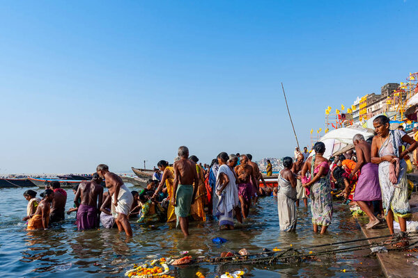 Индия, Варанаси - 23 апреля 2011 года: Неизвестные принимают ритуальные ванны в реке Ганга. Святая ритуальная баня проводится каждый день
