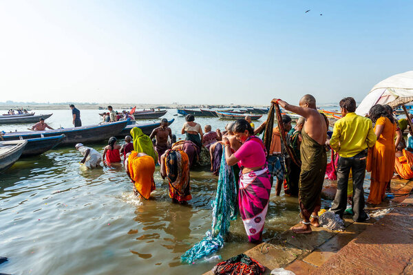 Индия, Варанаси - 23 апреля 2011 года: Неизвестные принимают ритуальные ванны в реке Ганга. Святая ритуальная баня проводится каждый день