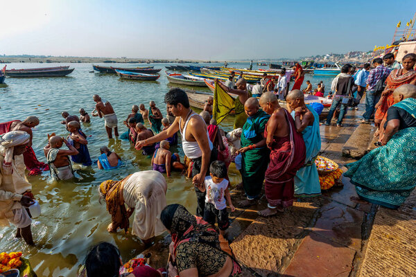 Индия, Варанаси - 23 апреля 2011 года: Неизвестные принимают ритуальные ванны в реке Ганга. Святая ритуальная баня проводится каждый день