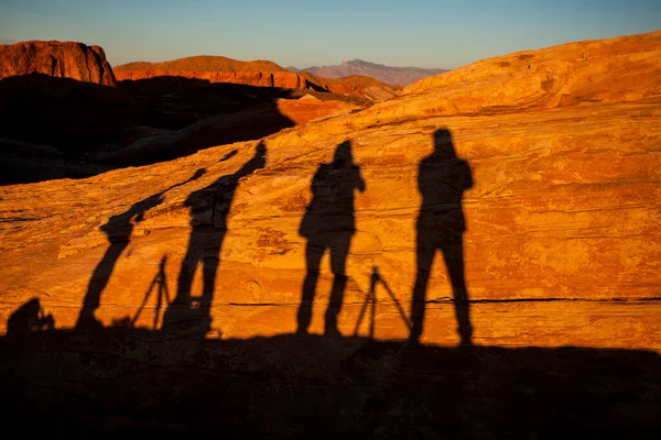 Shadow silhouettes of people on sunset landscape in Valley of Fire State Park