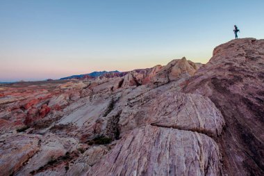  Pembe kayalar ve Ateş Vadisi 'nin arka planında destansı günbatımı olan dağlar. 