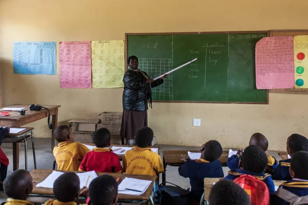 PIGGS PEAK, SWAZILAND - 29 Temmuz 2008 'de Nazarene Mission School, Piggs Peak, Svaziland' da çocukları inceleyen tanımlanamayan öğretmen