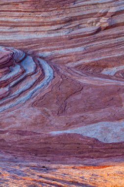 Ateş Vadisi 'ndeki pembe, mor ve parlak renkli çizgilerle karışık kayaların tepesinden bak. 