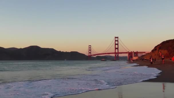 2018年加州旧金山贝克海滩的不明身份者背景为金门大桥 — 图库视频影像