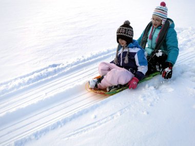 Kış çocuk eğleniyor sıcak giysiler ile karda kızakla