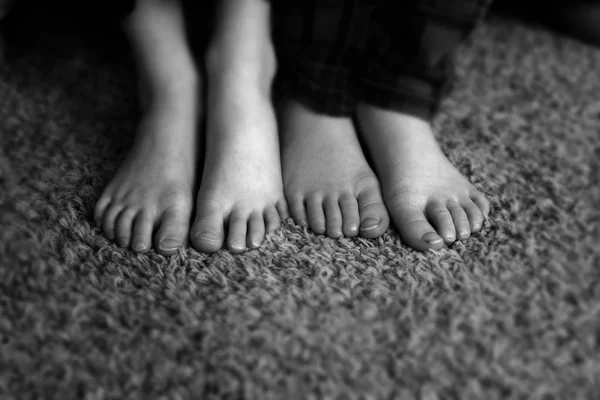 Children feet on carpet with pajamas youth young