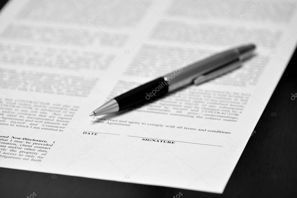 Contract with pen on desk signing business transaction