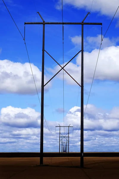 Powerlines-ban mező-val kék ég és felhők — Stock Fotó