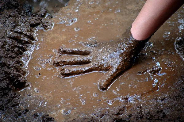 Kind Hand in Schlamm und Wasser spielt schlammig nass — Stockfoto