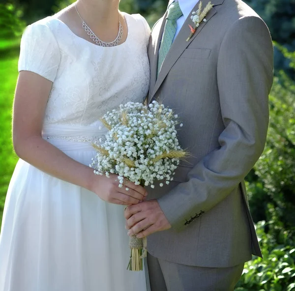 Panna młoda i pan młody stojący Holding boquet — Zdjęcie stockowe