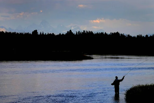 背景にティトンを持つ川のフライフィッシャーマン — ストック写真
