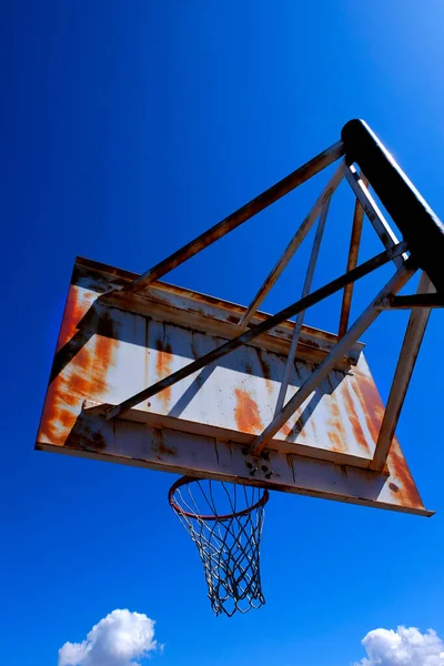 錆びた古い金属バスケットボールフープ外に対して青空上の遊び場 — ストック写真