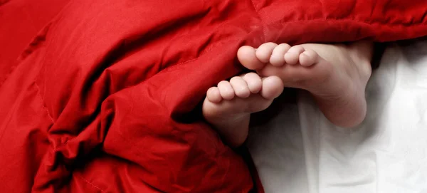 Niña Durmiendo Con Los Pies Asomándose Las Mantas — Foto de Stock