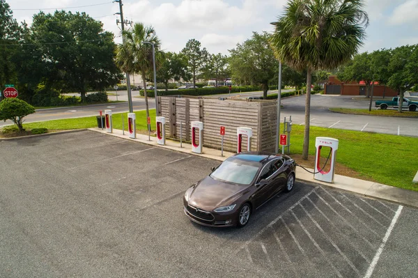 stock image Aerial image of a tesla Model s at a supercharger plugged in