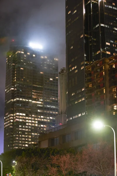 Fotografía nocturna arquitectura de rascacielos con niebla pesada —  Fotos de Stock