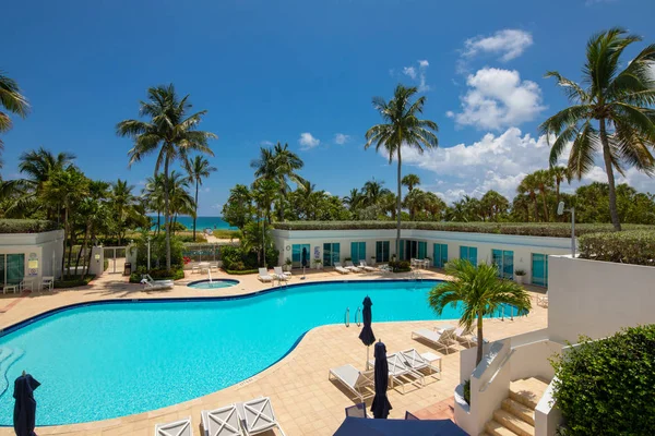 库存照片度假村游泳池与棕榈树和蓝天公寓酒店 — 图库照片