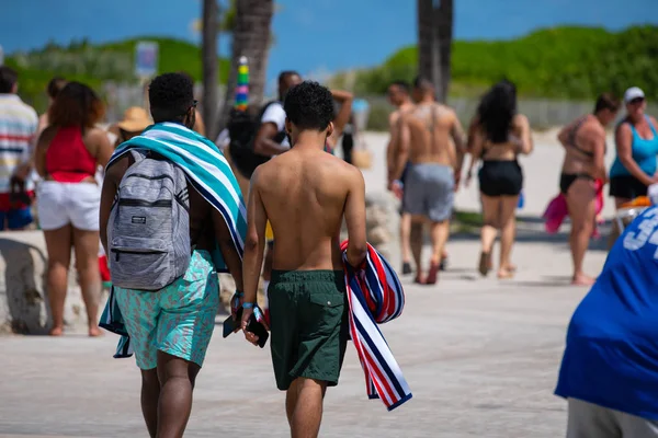 Młodzi mężczyźni spacerujący wzdłuż Miami Beach Ocean Drive letnie wakacje — Zdjęcie stockowe
