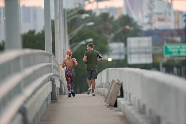 Couple d'âge mûr courant sur un trottoir de pont — Photo