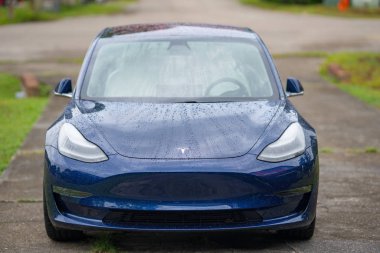 Tesla Model 3 mavi ve yağmurda