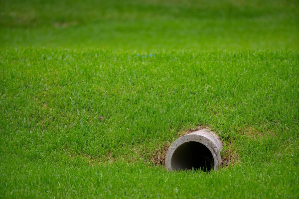 Pipa pembuangan keluar dari rumput — Stok Foto