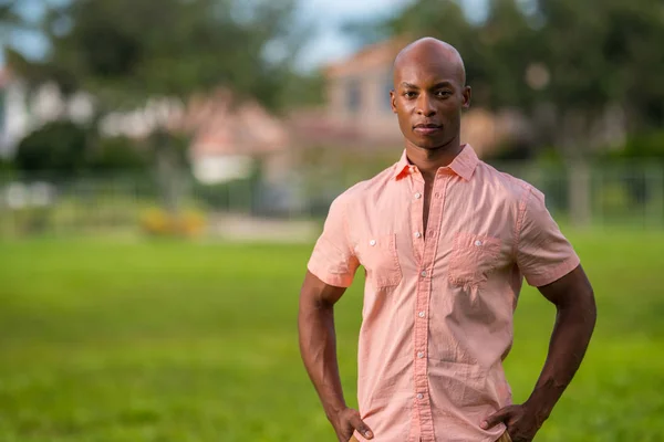Afrikanisch-amerikanischer Mann posiert im rosa Hemd in einem Park vor unserer Haustür — Stockfoto