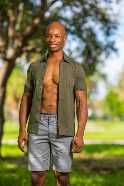 Photo of an attractive young bald black man smiling at camera. A — Stock Photo, Image