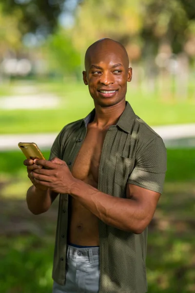 Hombre guapo enviando un mensaje en su teléfono inteligente y echando un vistazo — Foto de Stock