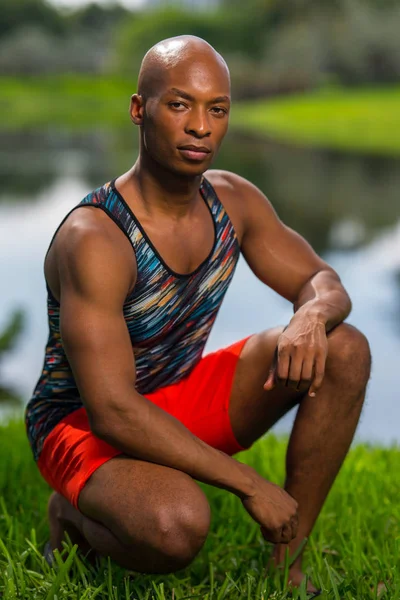 Retrato de um jovem bonito num poste de cócoras. Modelo masculino — Fotografia de Stock