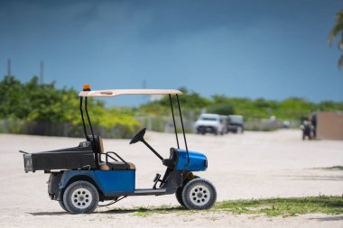 Telefoto lens ile çekilen plajda bir golf arabası fotoğrafı