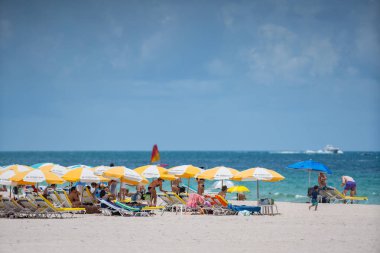 Miami plajında turistler. Sahilde bir gün için hazırlanıyor