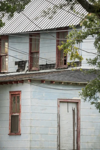 Old ditinggalkan rumah dengan garis listrik menyeberang di depan — Stok Foto