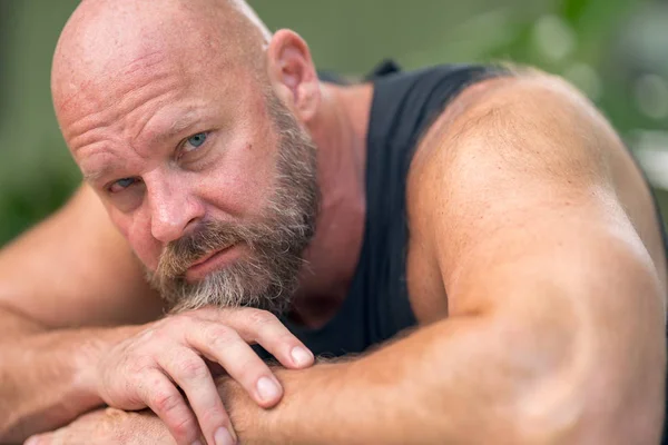 Photo of a man laying his head on arms looking into camera — Stock Photo, Image