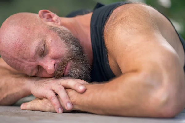 Man slaapt op zijn armen aan tafel — Stockfoto