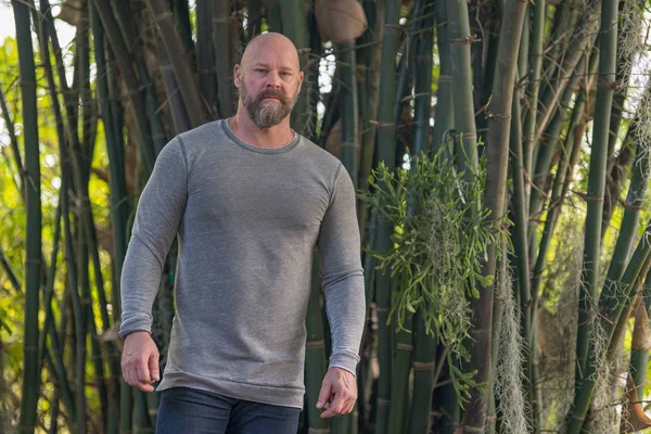 Homem duro posando em um jardim de bambu — Fotografia de Stock