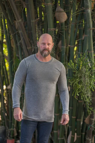 Imagem de um homem barbudo careca posando em uma camisa de manga comprida outdoo — Fotografia de Stock