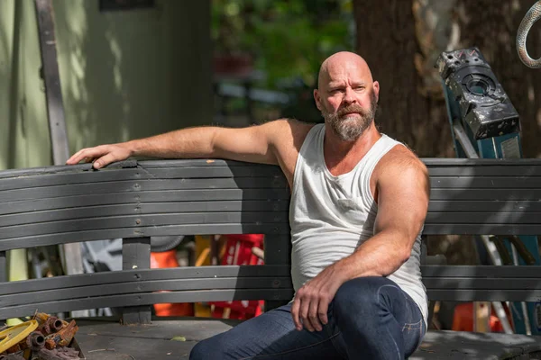 Arbeitsloser Amerikaner sitzt draußen auf einer Bank und trägt eine Sonnenbrille — Stockfoto
