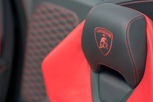 Logotipo Lamborghini cosido en un asiento de coche deportivo de cuero rojo y b —  Fotos de Stock