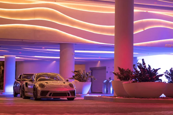 Porsche GT3RS garée à une rampe de voiturier d'hôtel néon lumineux coloré — Photo